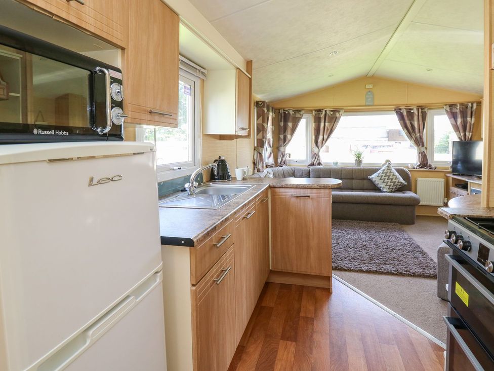 A kitchen area with appliances and seating at Caravan 2 at Blackmoor Farm near tenby