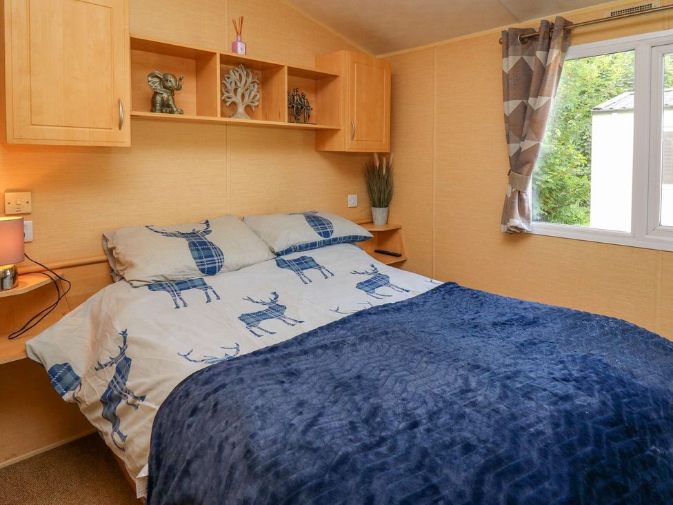 A bedroom with a bed and shelves at Caravan 2 at Blackmoor Farm near tenby