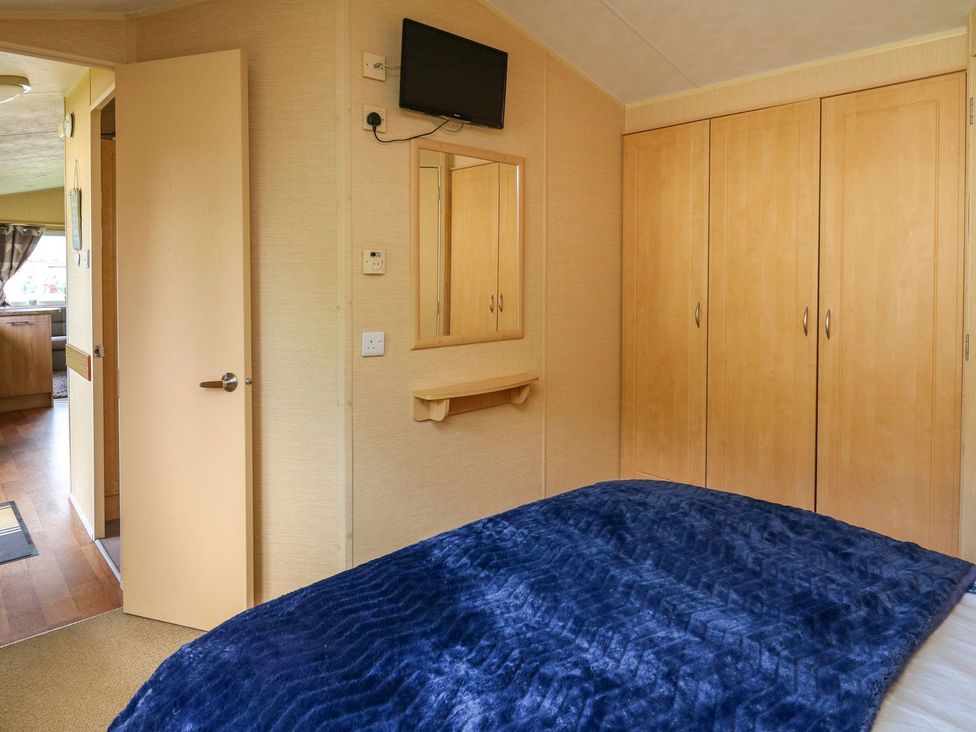 A bedroom with a bed and television at Caravan 2 at Blackmoor Farm near tenby Narberth