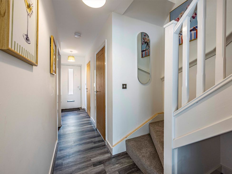 A hallway with a front door and staircase at 8 Riverside Mews in Derby