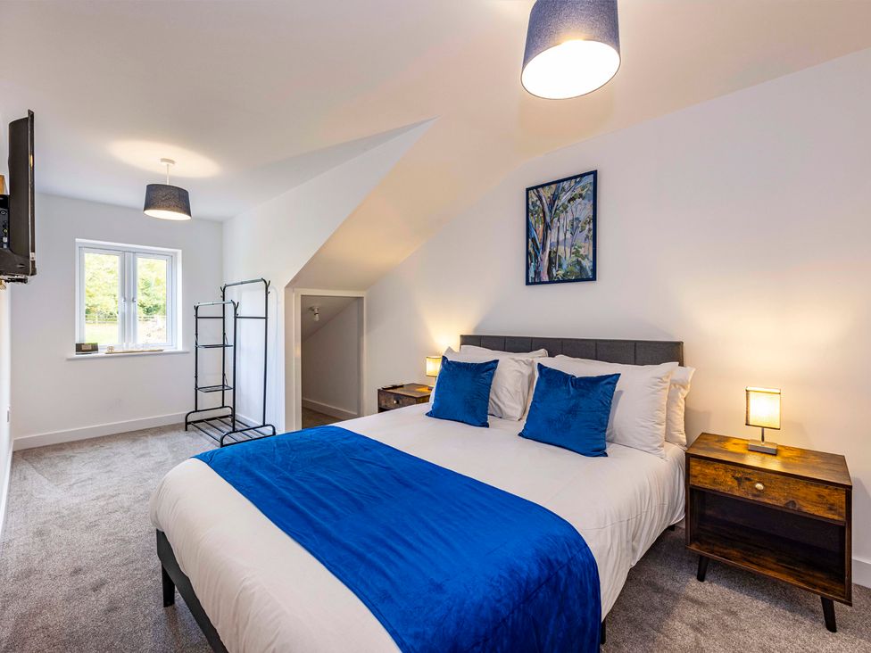 A bedroom with a bed and nightstands at 8 Riverside Mews in Derby