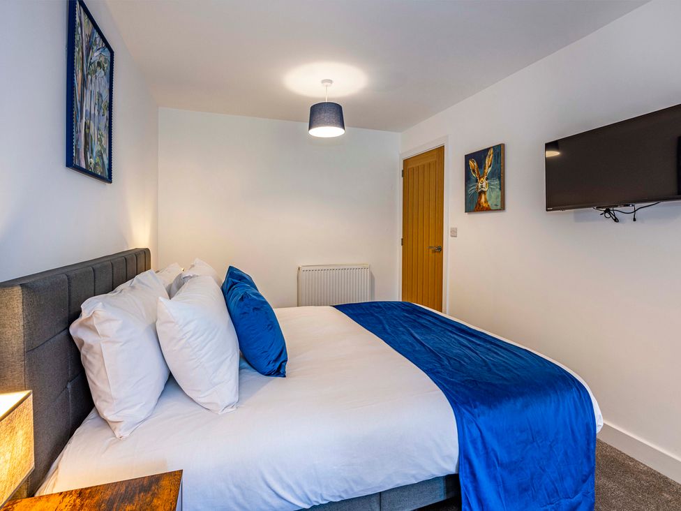 A bedroom with a bed and a TV at 8 Riverside Mews in Derby
