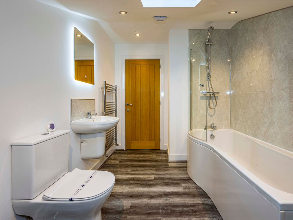 A bathroom featuring a bathtub, sink, toilet, and shower at 8 Riverside Mews in Derby