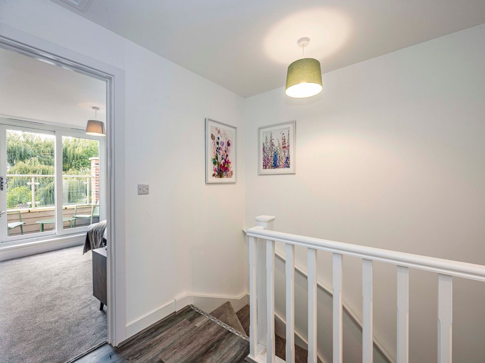 A hallway with a staircase and artwork at 8 Riverside Mews in Derby