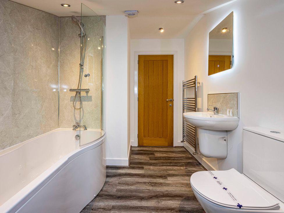 A bathroom with a bathtub, shower, sink, and toilet at 8 Riverside Mews in Derby