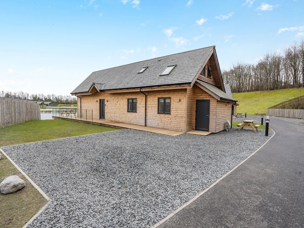 A log cabin with a gravel area and a wooden table at Tranquillity 4 in Carnforth