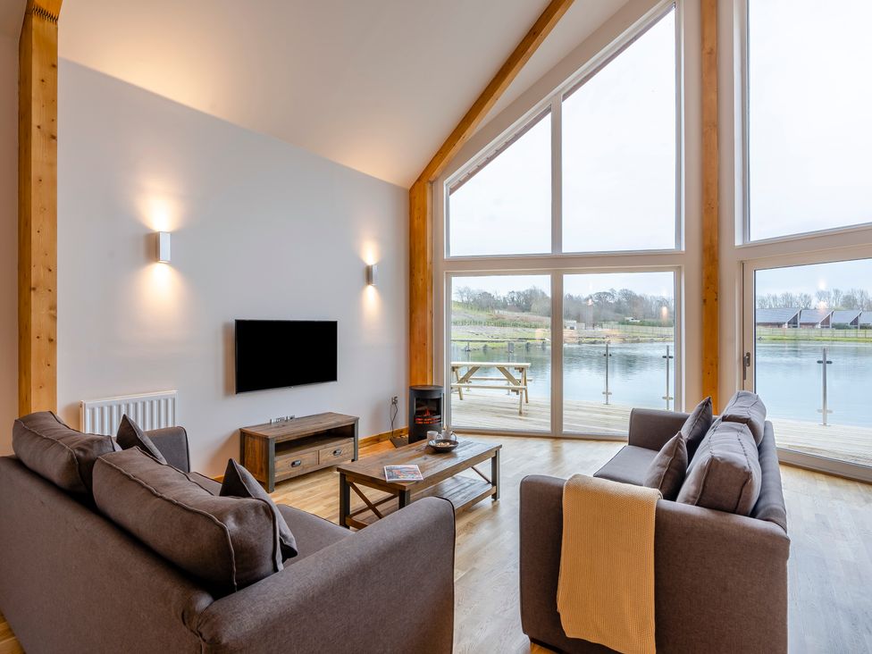 A living room with a television and coffee table at Tranquillity 4 in Carnforth
