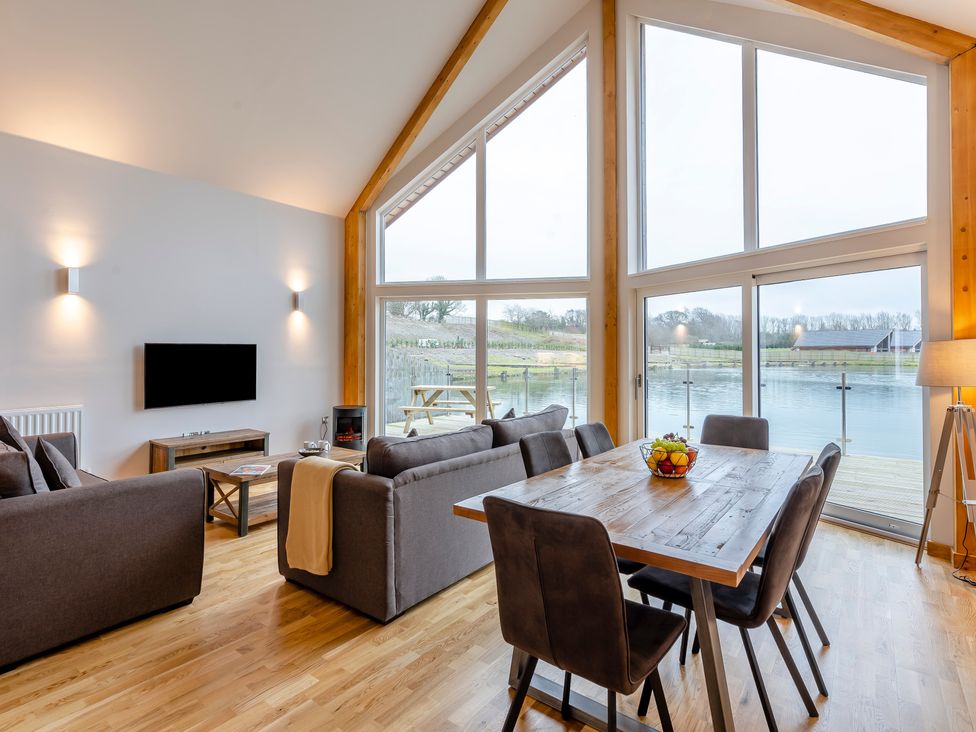 A living room with a sofa and dining area at Tranquillity 4 Carnforth