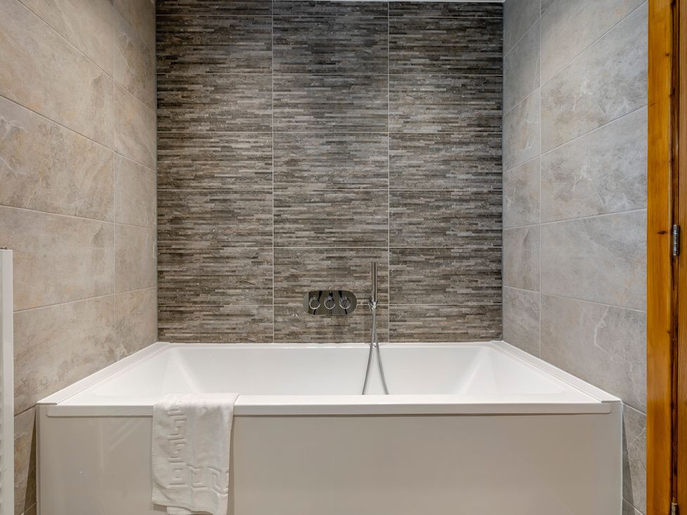 A bathtub with a towel in a bathroom at Tranquillity 4 in Carnforth