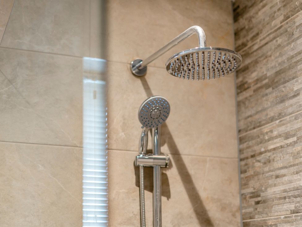 A shower with a fixed and handheld shower head at Tranquillity 4 in Carnforth