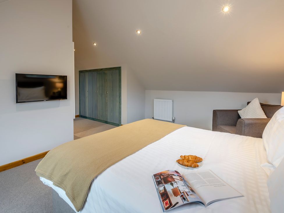 A bedroom with a bed and croissant on a table at Tranquillity 4 in Carnforth