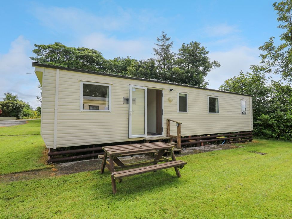 A caravan with a wooden steps and picnic table at Caravan 3 at Blackmoor Farm near tenby
