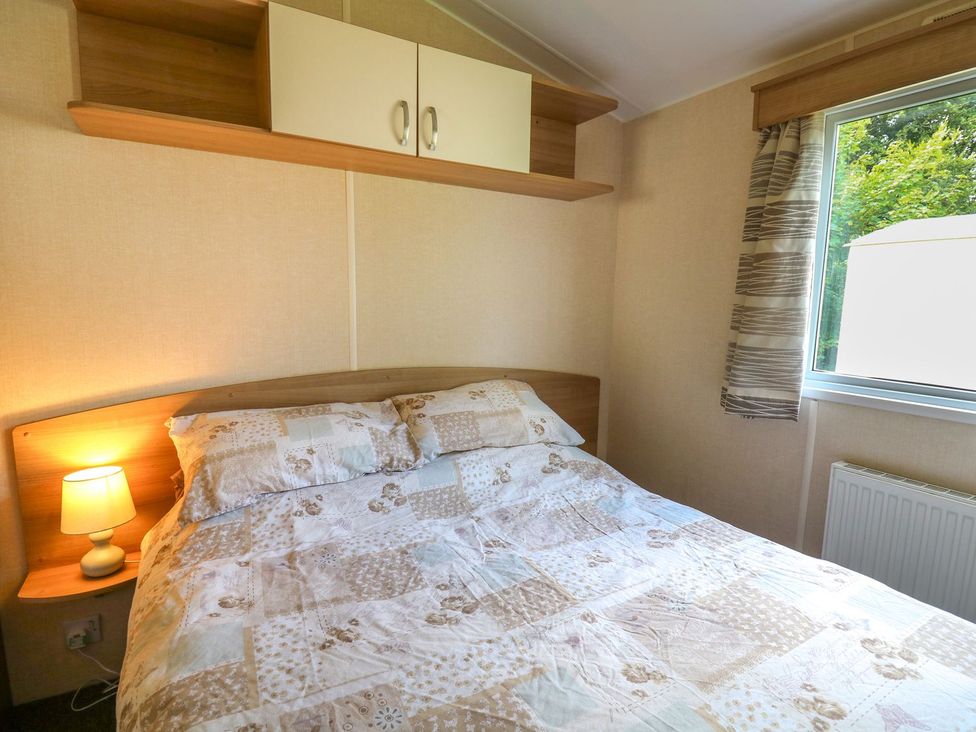 A bedroom with a bed and a window at Caravan 3 at Blackmoor Farm near tenby