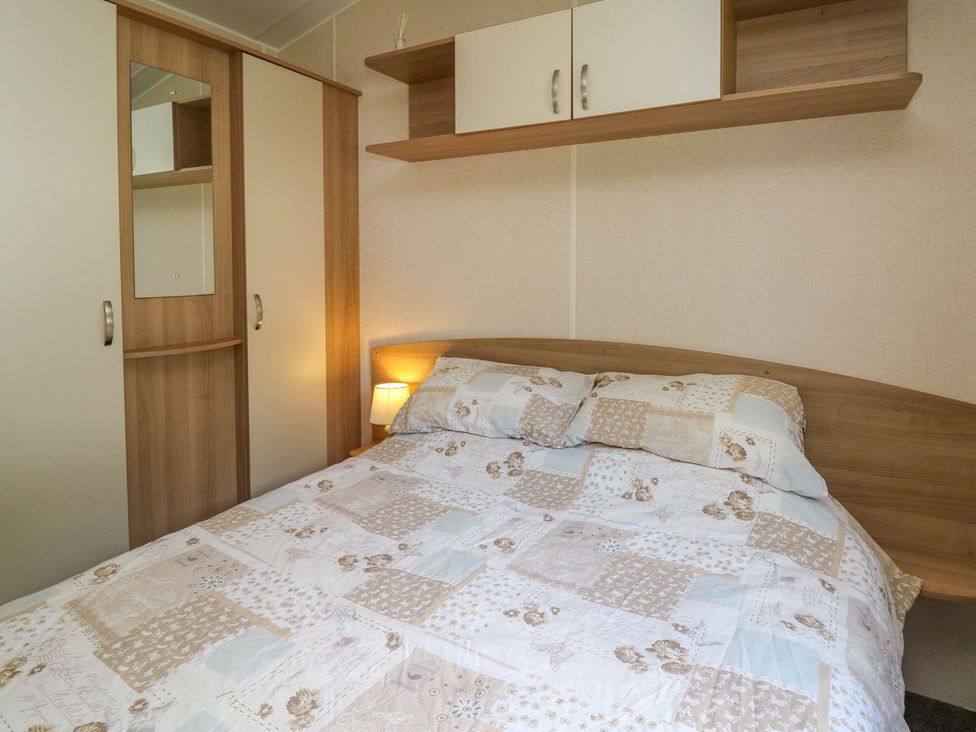 A bedroom with a bed and wardrobe at Caravan 3 at Blackmoor Farm near tenby Narberth