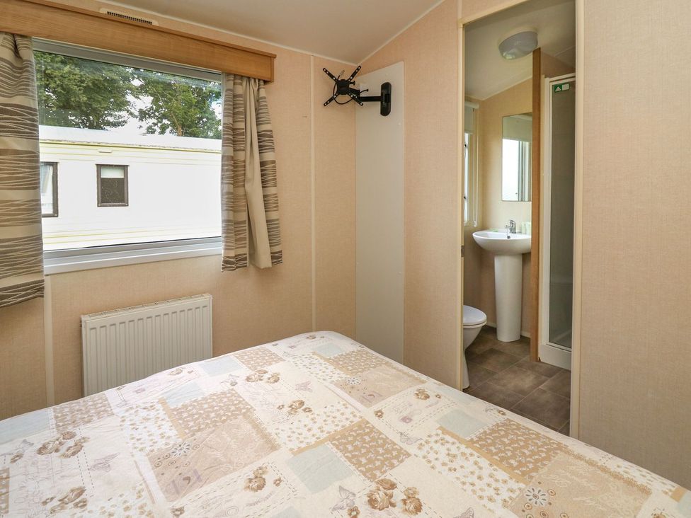 A bedroom with a bed and an adjoining bathroom at Caravan 3 at Blackmoor Farm near tenby
