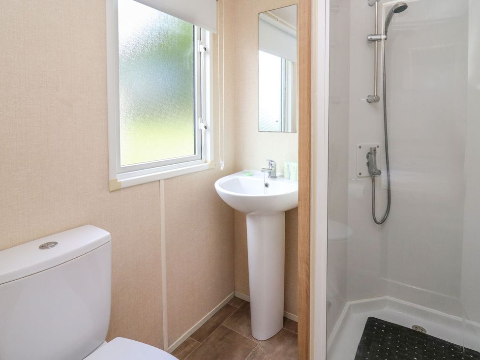 A bathroom with a shower, toilet, and sink at Caravan 3 at Blackmoor Farm near tenby in Narberth
