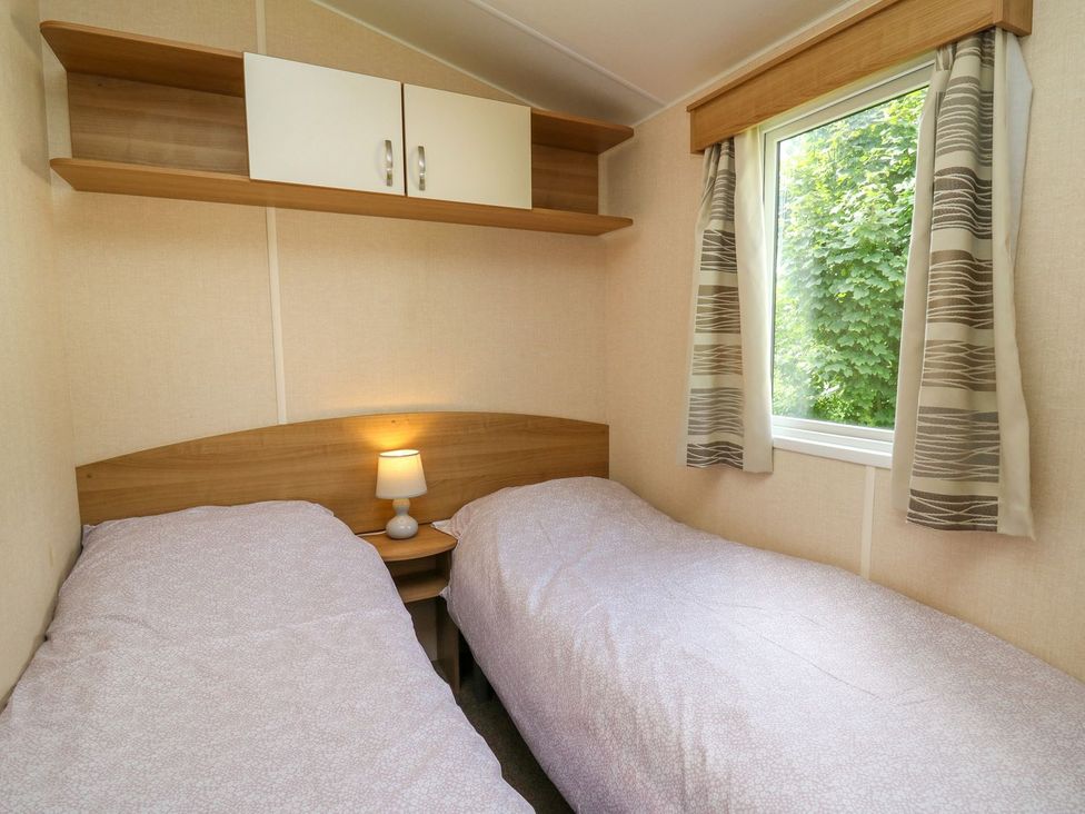 A bedroom with two beds and a lamp at Caravan 3 at Blackmoor Farm near tenby