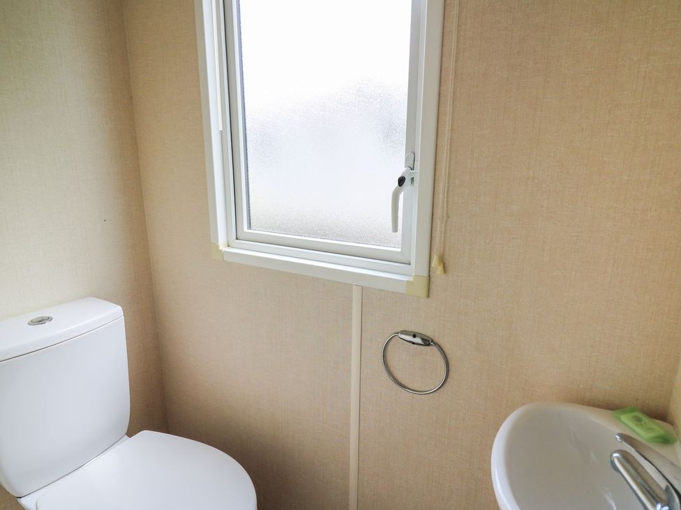 A bathroom with a toilet and washbasin at Caravan 3 at Blackmoor Farm near tenby