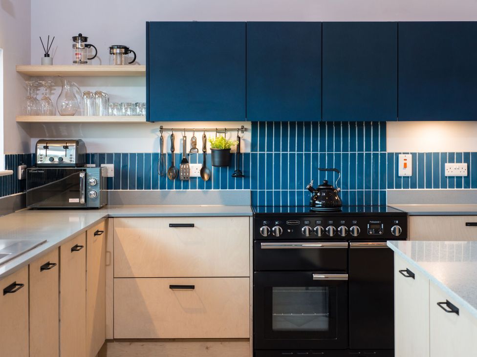 A kitchen with cabinets, countertop, oven, kettle, and microwave at The Irvine in North Berwick