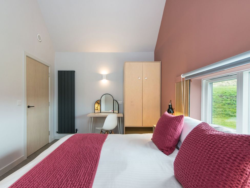 A bedroom with a bed, wardrobe, and desk at The Irvine in North Berwick