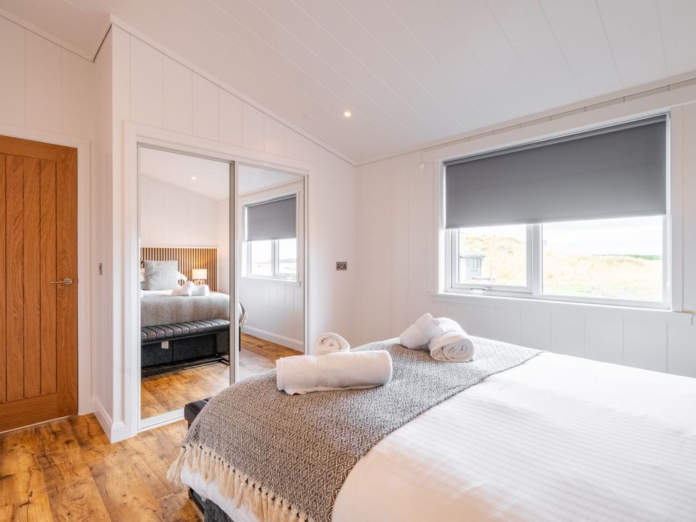 A bedroom with a bed and mirror at The Townsend in North Berwick
