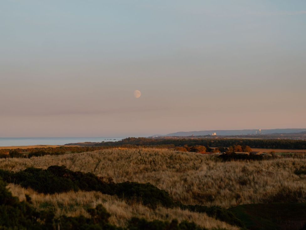 A view of the ocean and moon over grassland at The Laidlaw Spa in North Berwick