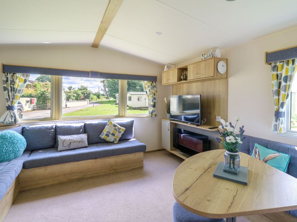 A living room with a sofa and television at Caravan 6 at Blackmoor Farm near tenby