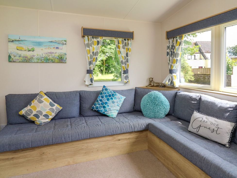 A living room with a couch and paintings at Caravan 6 at Blackmoor Farm near tenby