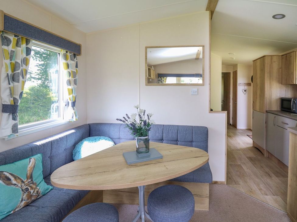 A dining area with a table and seating at Caravan 6 at Blackmoor Farm near tenby