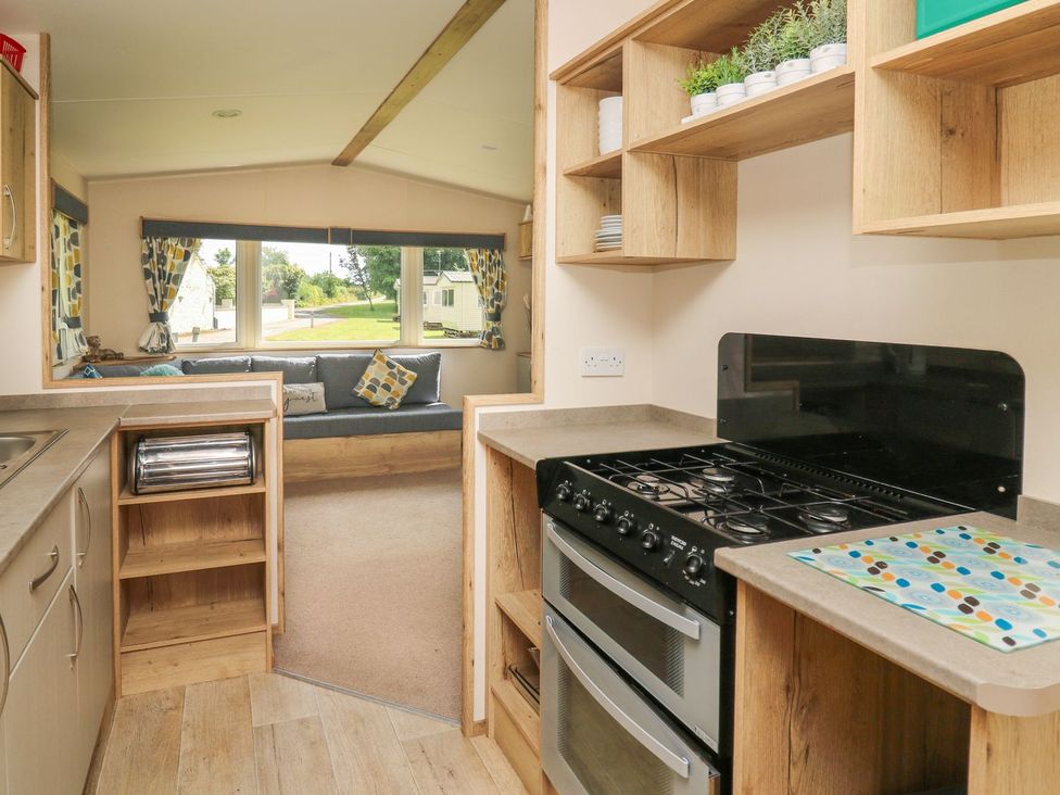 A kitchen with a gas stove and sink at Caravan 6 at Blackmoor Farm near tenby