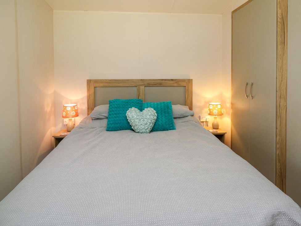 A bedroom with a bed and nightstand at Caravan 6 at Blackmoor Farm near tenby