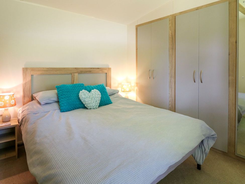 A bedroom with a bed and wardrobe at Caravan 6 at Blackmoor Farm near tenby Narberth