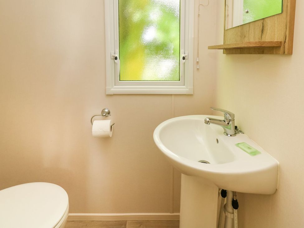 A bathroom with a toilet and sink at Caravan 6 at Blackmoor Farm near tenby