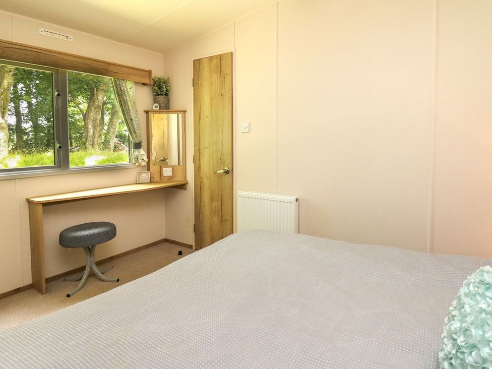 A bedroom with a desk and mirror at Caravan 6 at Blackmoor Farm near tenby