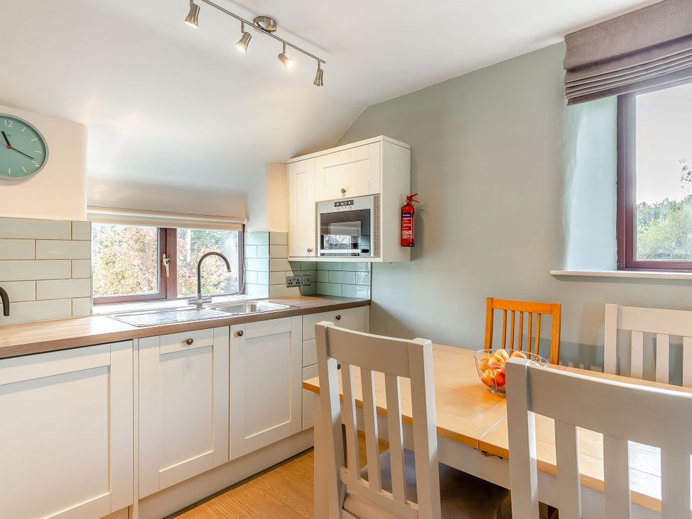 A kitchen with a sink and dining area at Crabtree Cottage in Bude