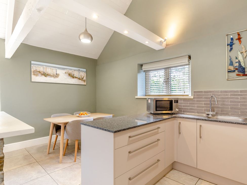 A kitchen with a table and chairs at Godolphin Stable Bude