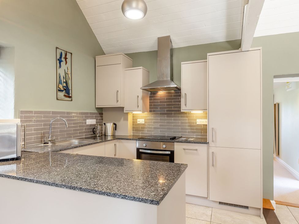 A kitchen with cabinets and appliances at Godolphin Stable in Bude