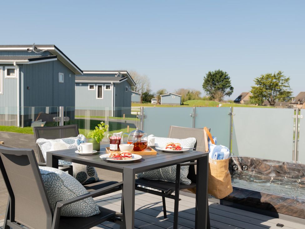 An outdoor dining area with a table and chairs at Kynance Spa in Bude
