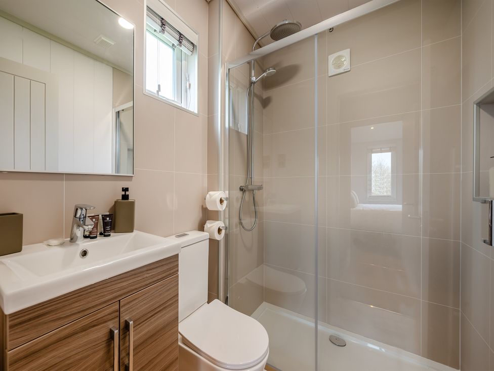 A bathroom with shower, toilet, and sink at Sennen 2 Spa Roof Terrace (Pet) Bude