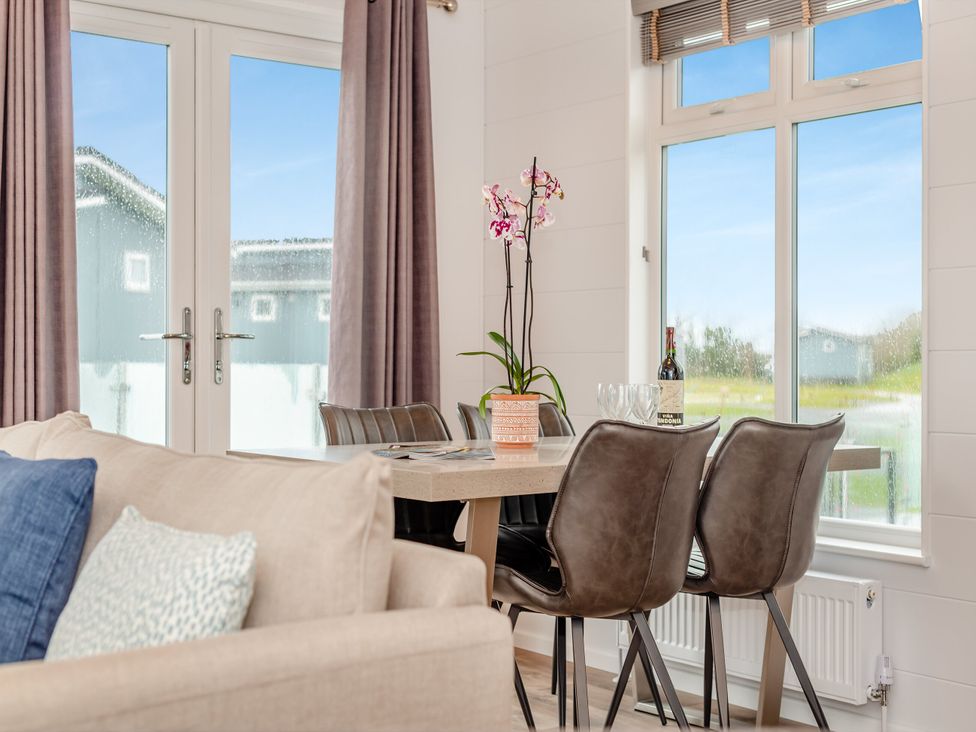 A dining room with a table and chairs at Kynance (Pet) Bude
