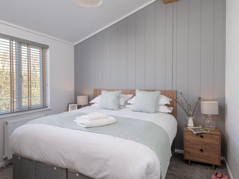 A bedroom with a bed and bedside table at Kynance (Pet) Bude
