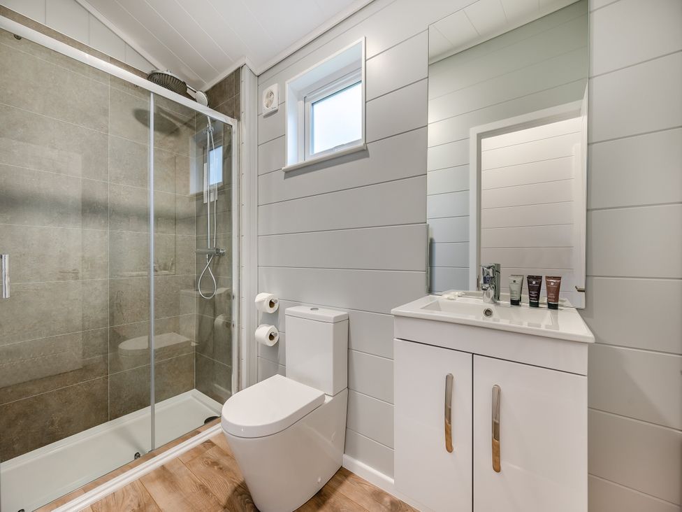 A bathroom with a shower, toilet, and sink at Kynance (Pet) Bude
