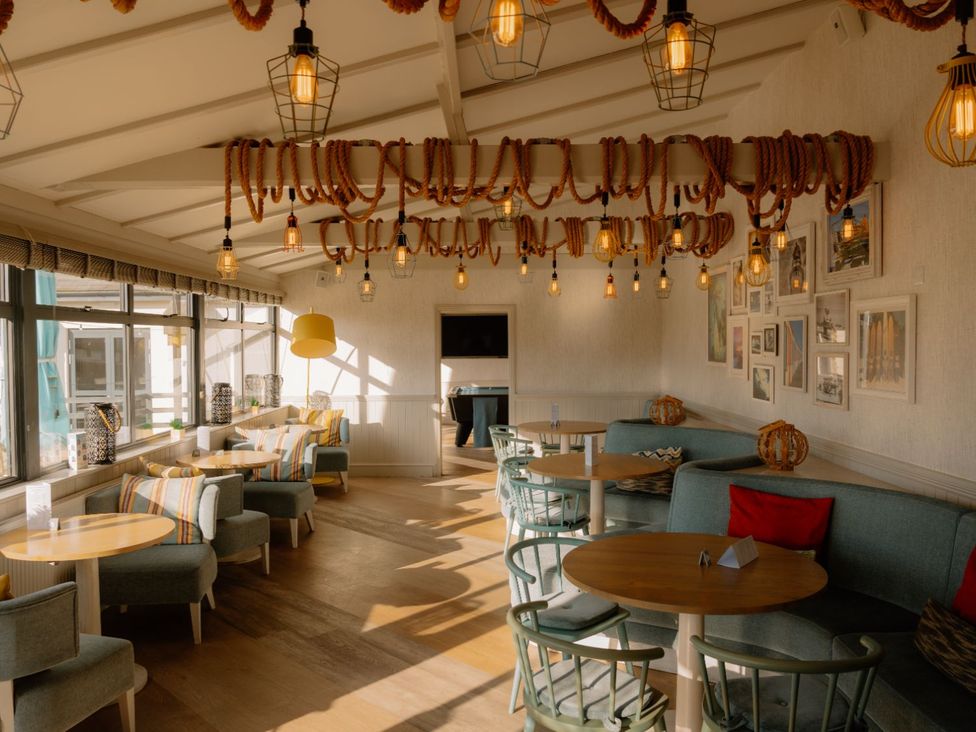 A common area with seating and light fixtures at Kynance (Pet) in Bude