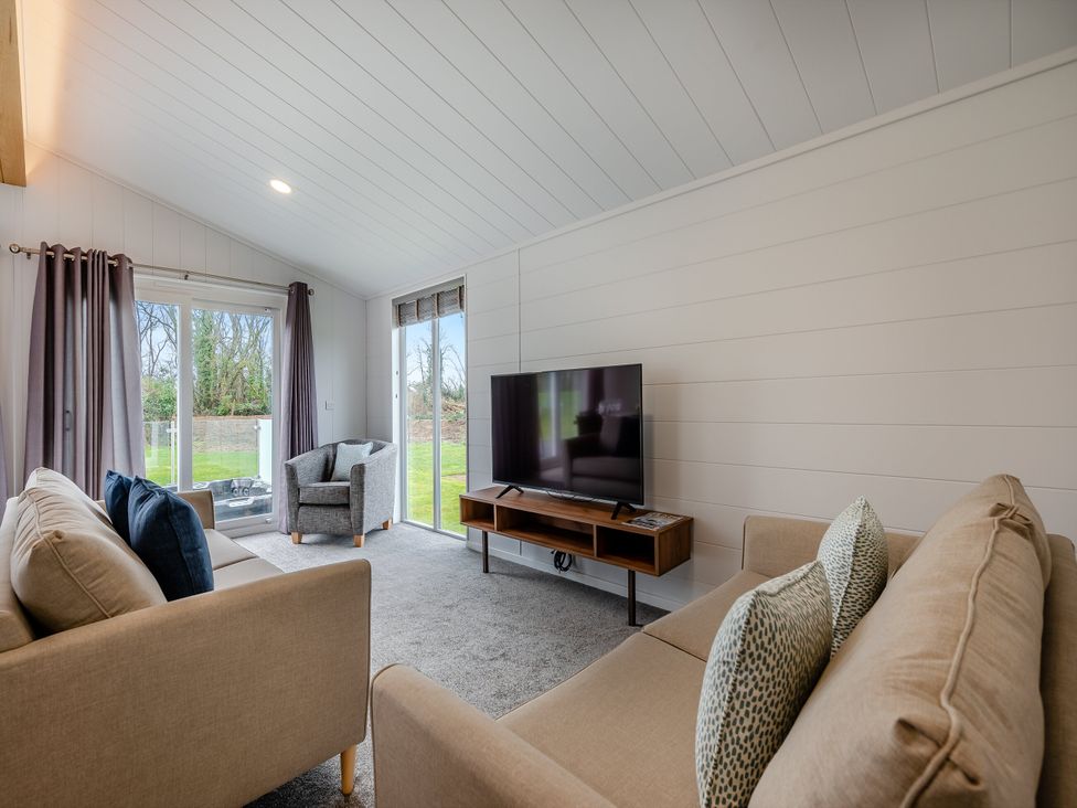 A living room with a sofa and television at Mullion 2 Spa (Pet) in Bude