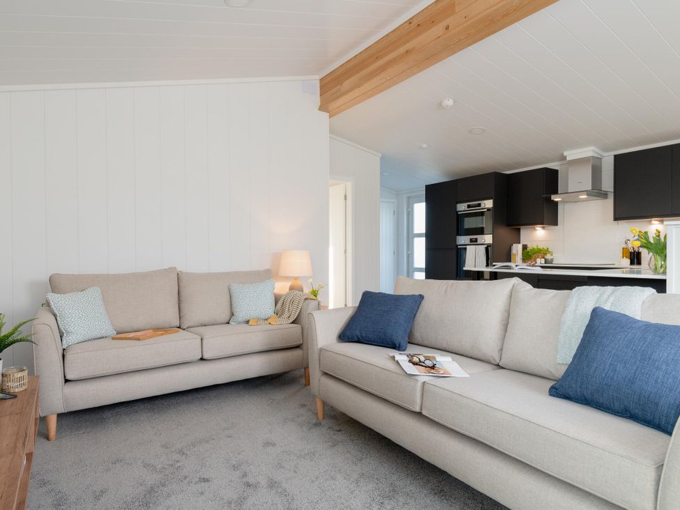 A living room with sofas and a lamp at Mullion 2 Spa (Pet) in Bude