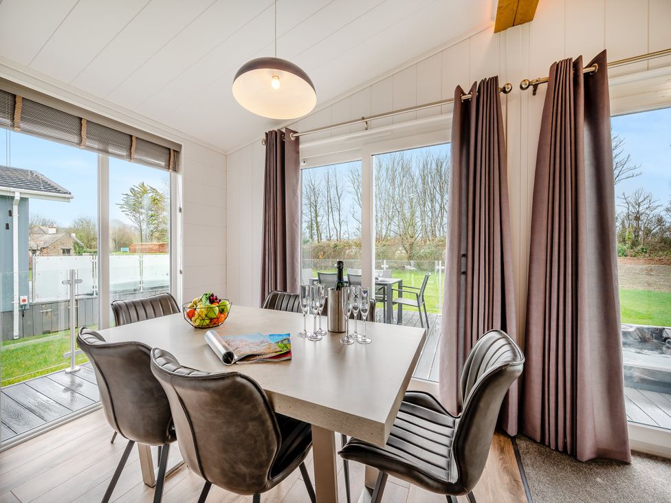 A dining room with a table and chairs at Mullion 2 Spa (Pet) Bude