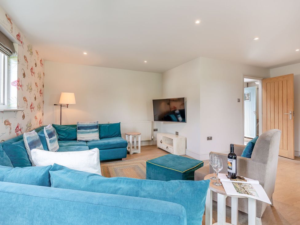 A living room with a television and sofa at Summerleaze Garden Cottage 3 Spa Bude