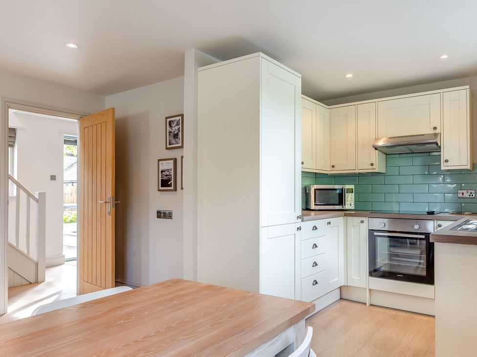 A kitchen with cabinets and appliances at Summerleaze Garden Cottage 3 Spa Bude