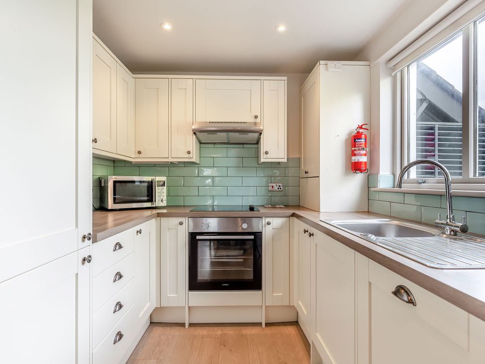 A kitchen with oven and microwave at Summerleaze Garden Cottage 3 Spa in Bude