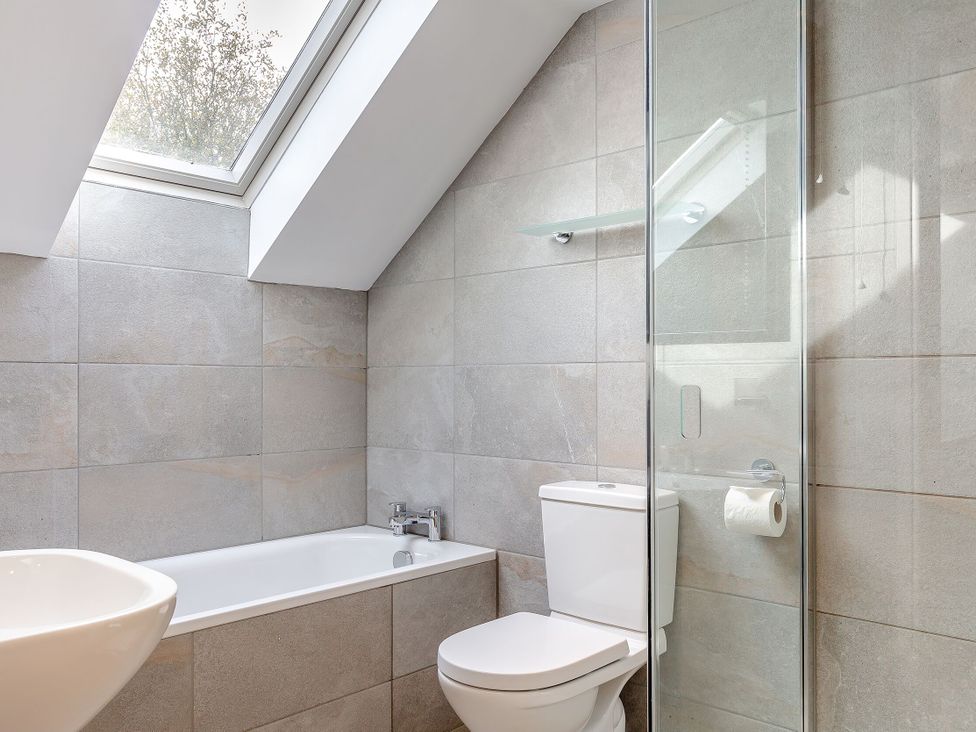A bathroom with a bathtub and toilet at Summerleaze Garden Cottage 3 Spa, Bude
